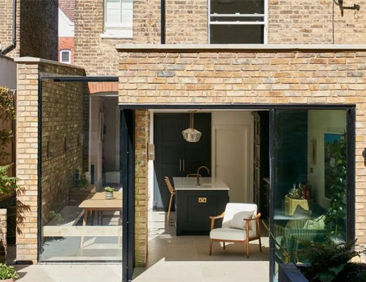semi-detached Victorian extension made of brown brick and glass, with modern furniture inside