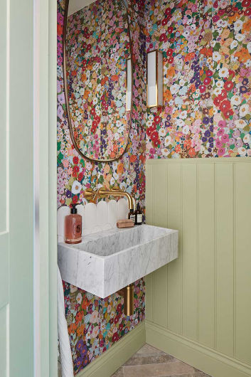 A cloakroom featuring floral wallpaper and half-height wall panelling painted in sage green