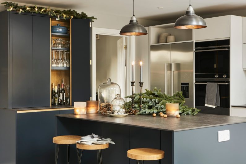 Festive kitchen decorations on the island with pine cones and candles 