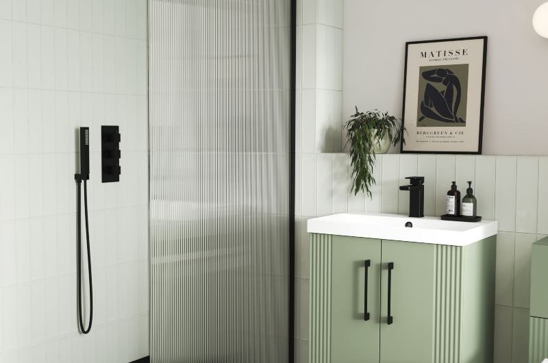 colourful bathroom with reeded shower enclosure, black shower tray and brassware, and green vanity unit